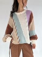 Woman wearing a colorful knitted sweater with a white background