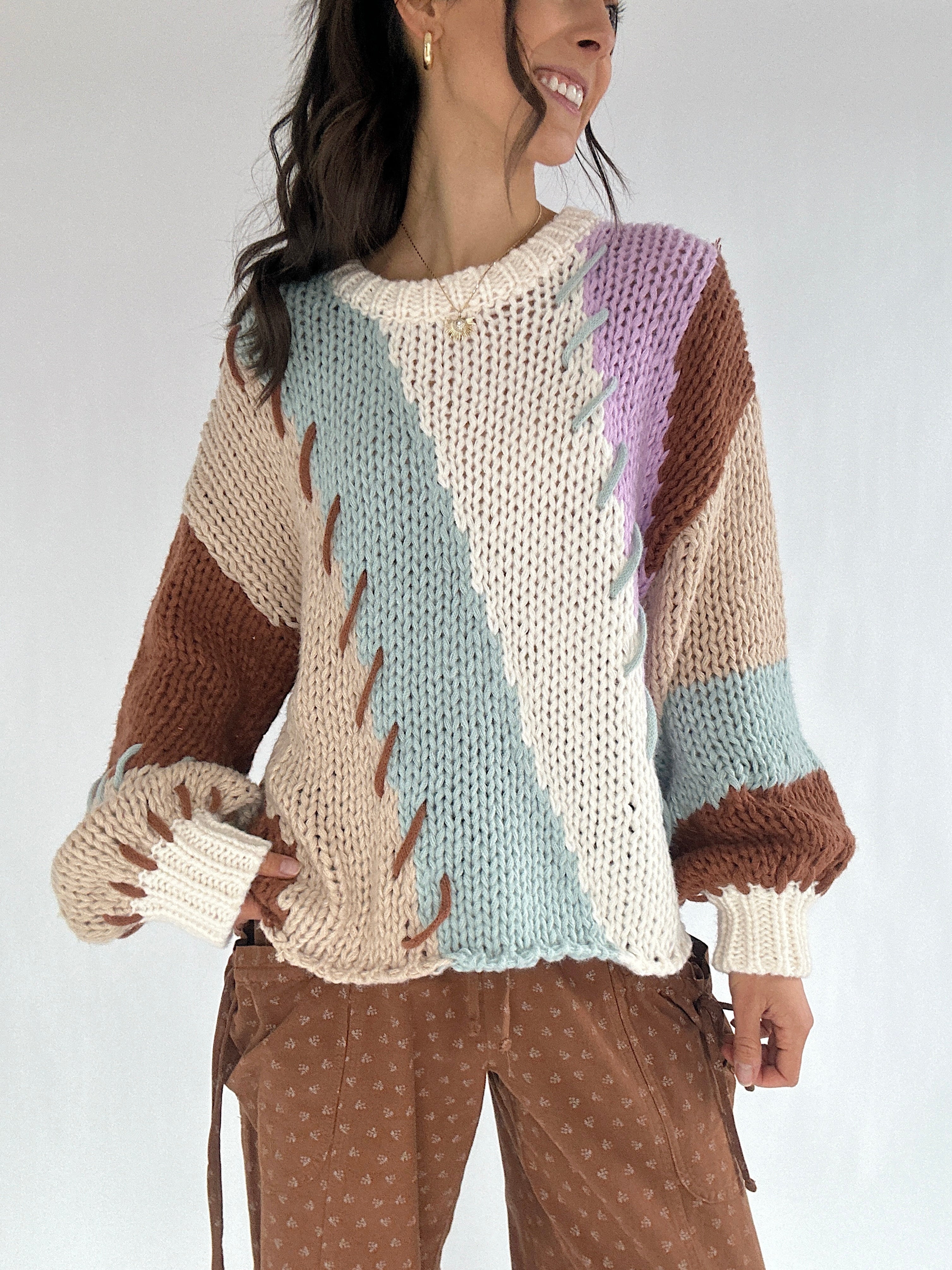 Woman wearing a colorful knitted sweater with a white background