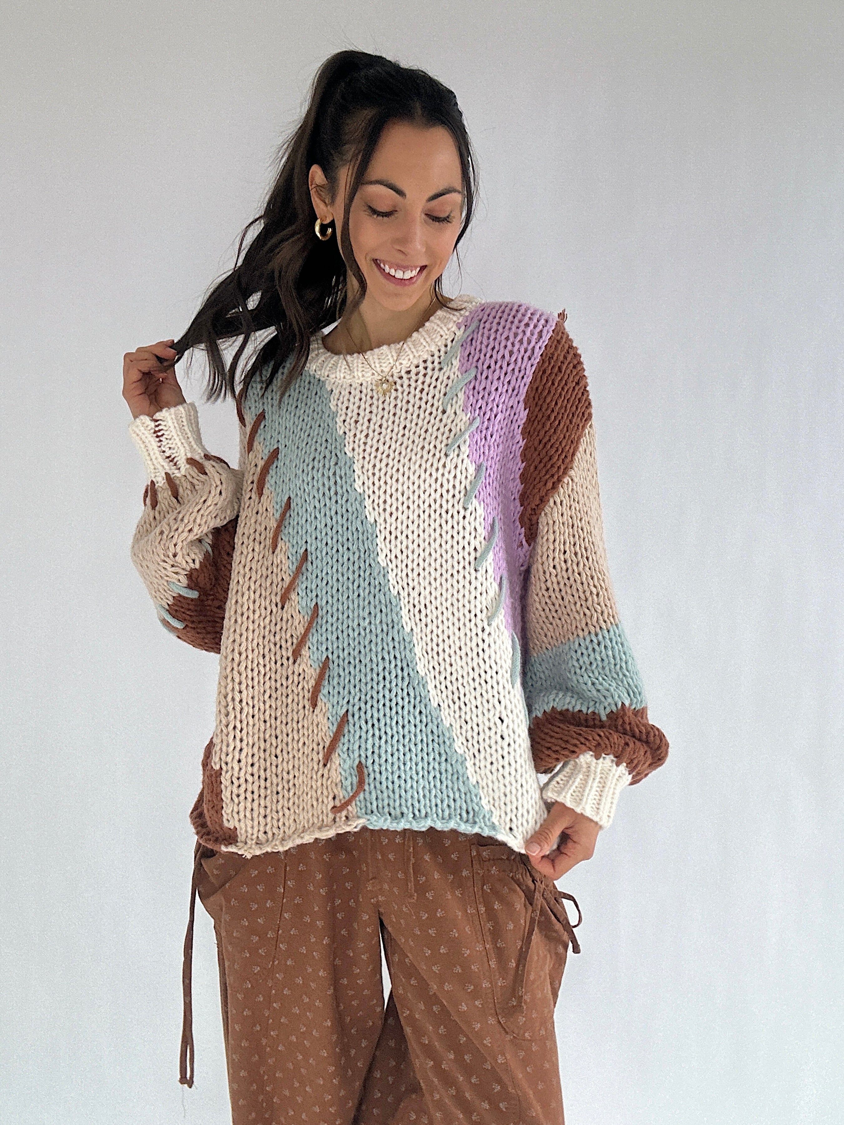 Woman wearing a colorful knitted sweater with a white background