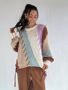 Woman wearing a colorful knitted sweater with a white background