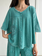 Teal textured outfit with crochet mandala patterns on a white background