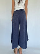 Person wearing blue waffle knit wide-leg pants on a white background showing back with one back pocket