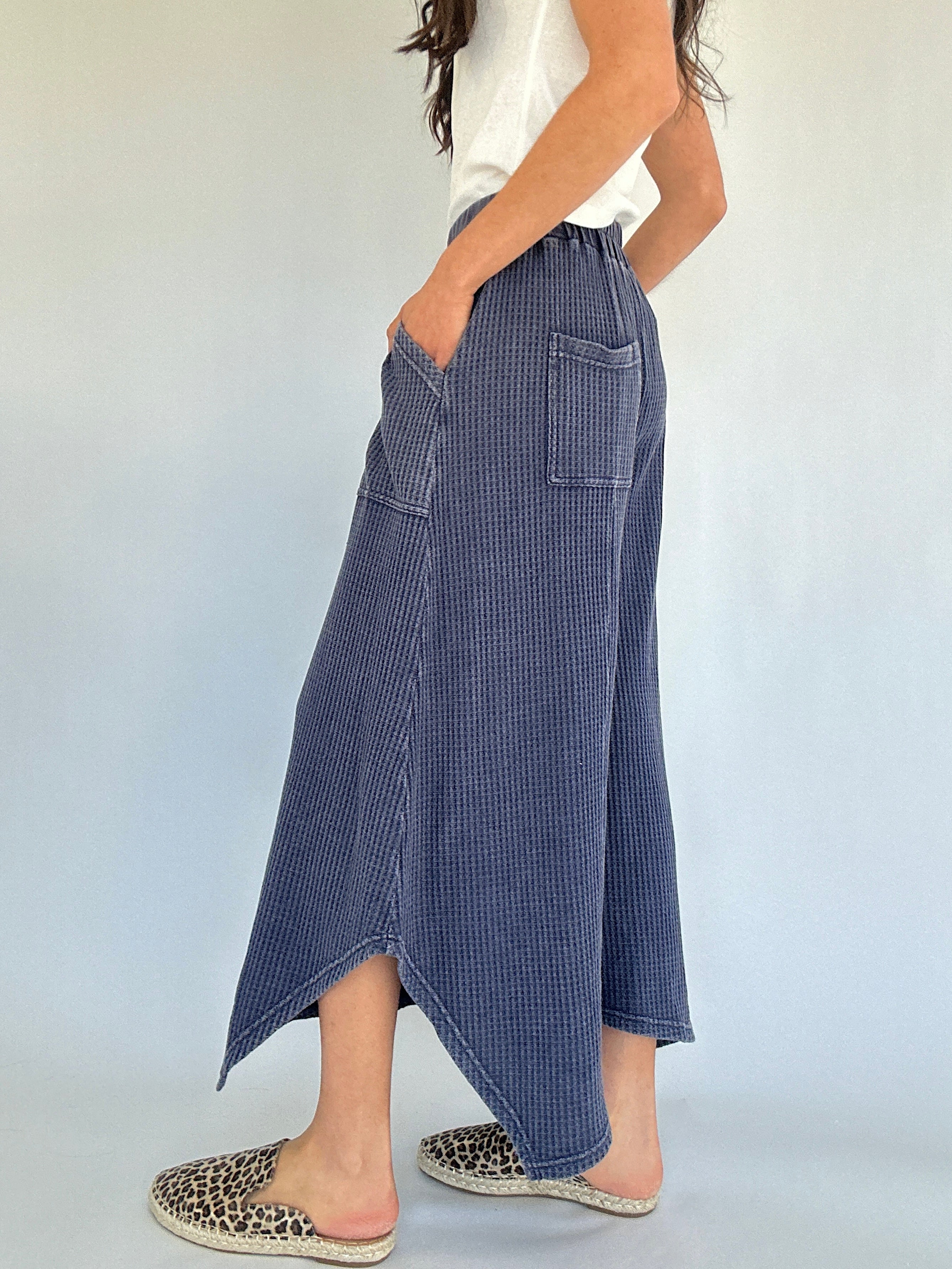 Person wearing blue waffle knit wide leg pants with a white background