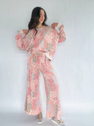Woman wearing a pink floral patchwork printed matching outfit on a white background