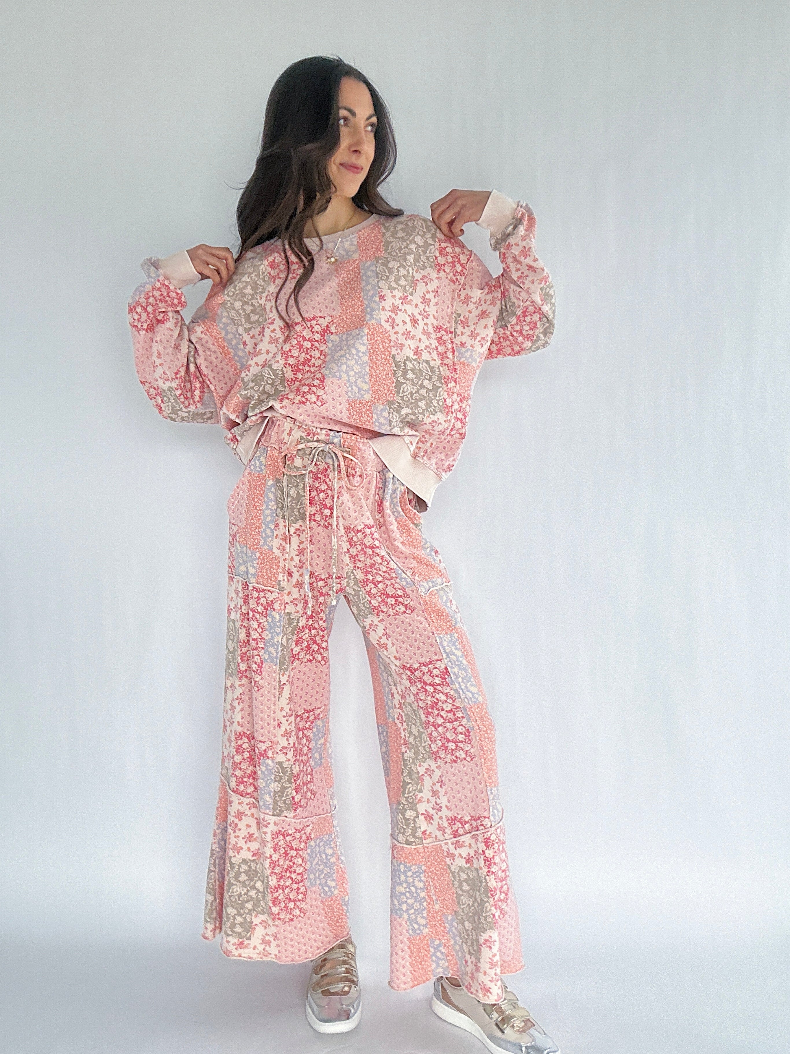 Woman wearing a pink floral patchwork printed matching outfit on a white background