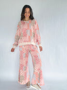 Woman wearing a floral patterned outfit on a white background