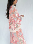 Woman wearing a floral patchwork printed matching outfit against a white background showing side