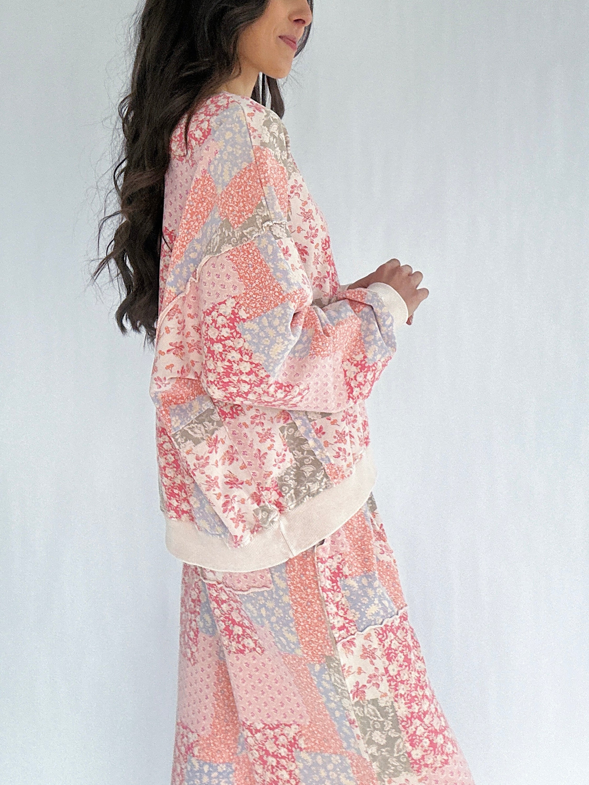 Woman wearing a floral patchwork printed matching outfit against a white background showing side