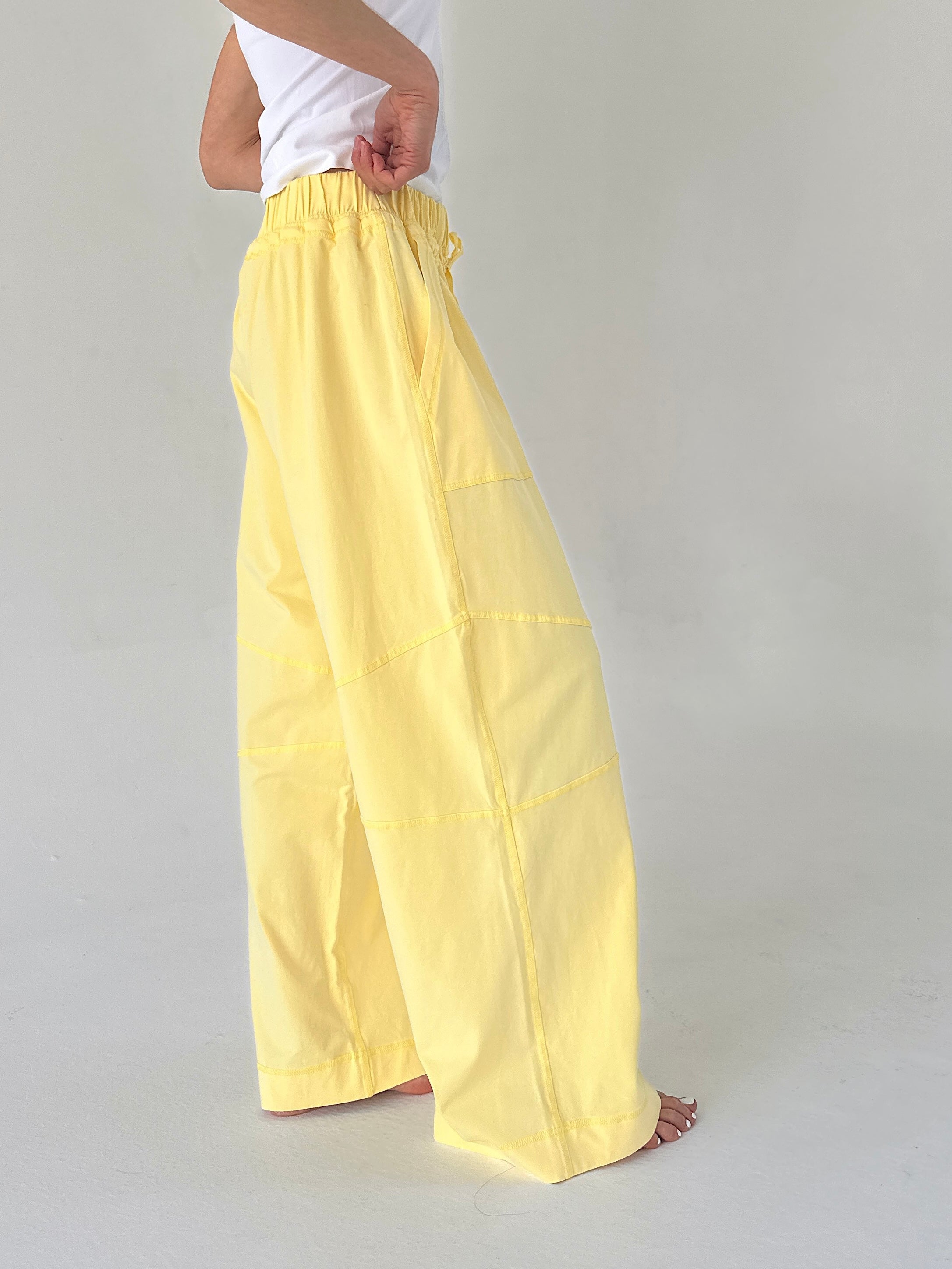 Person wearing yellow wide-leg pants on a plain background