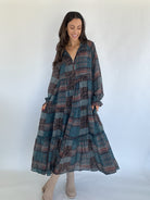 Woman wearing a long, patterned dress against a white background