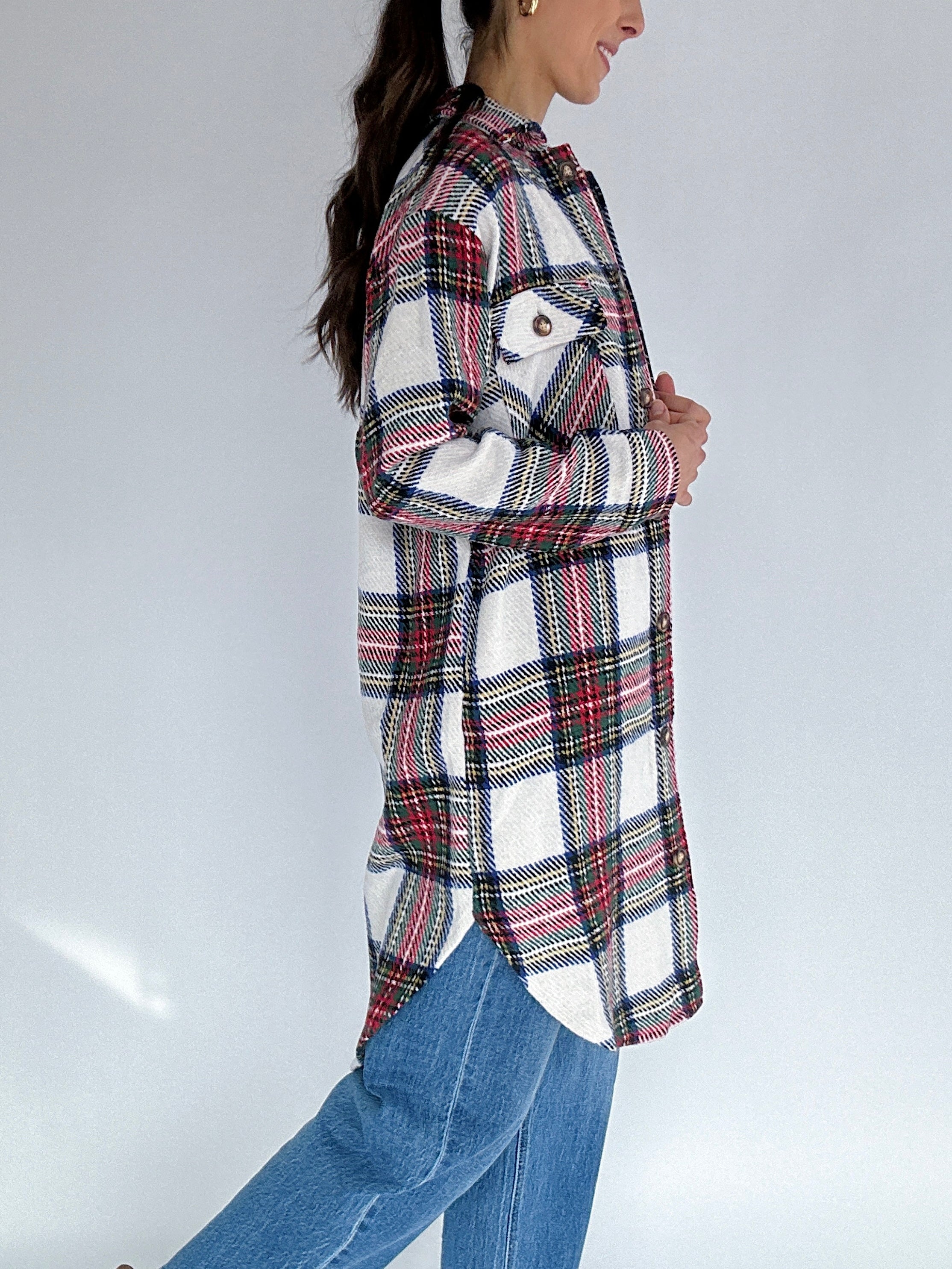 Person wearing a plaid jacket and jeans on a plain background